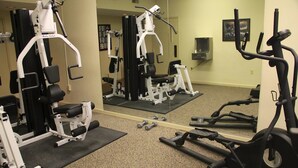 A gym with various exercise equipment, including a treadmill, weight machines, and dumbbells. - Gold Vault Inn (Radcliff)