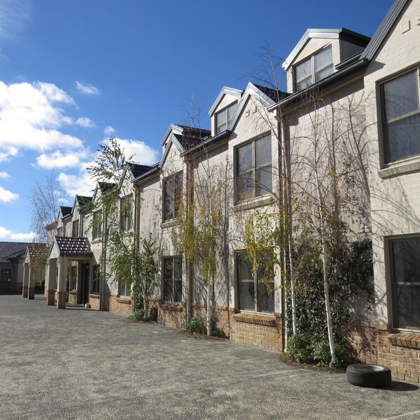 A row of townhouses with a gravel driveway and a clear blue sky. - Best Western Plus Goulburn (Goulburn)
