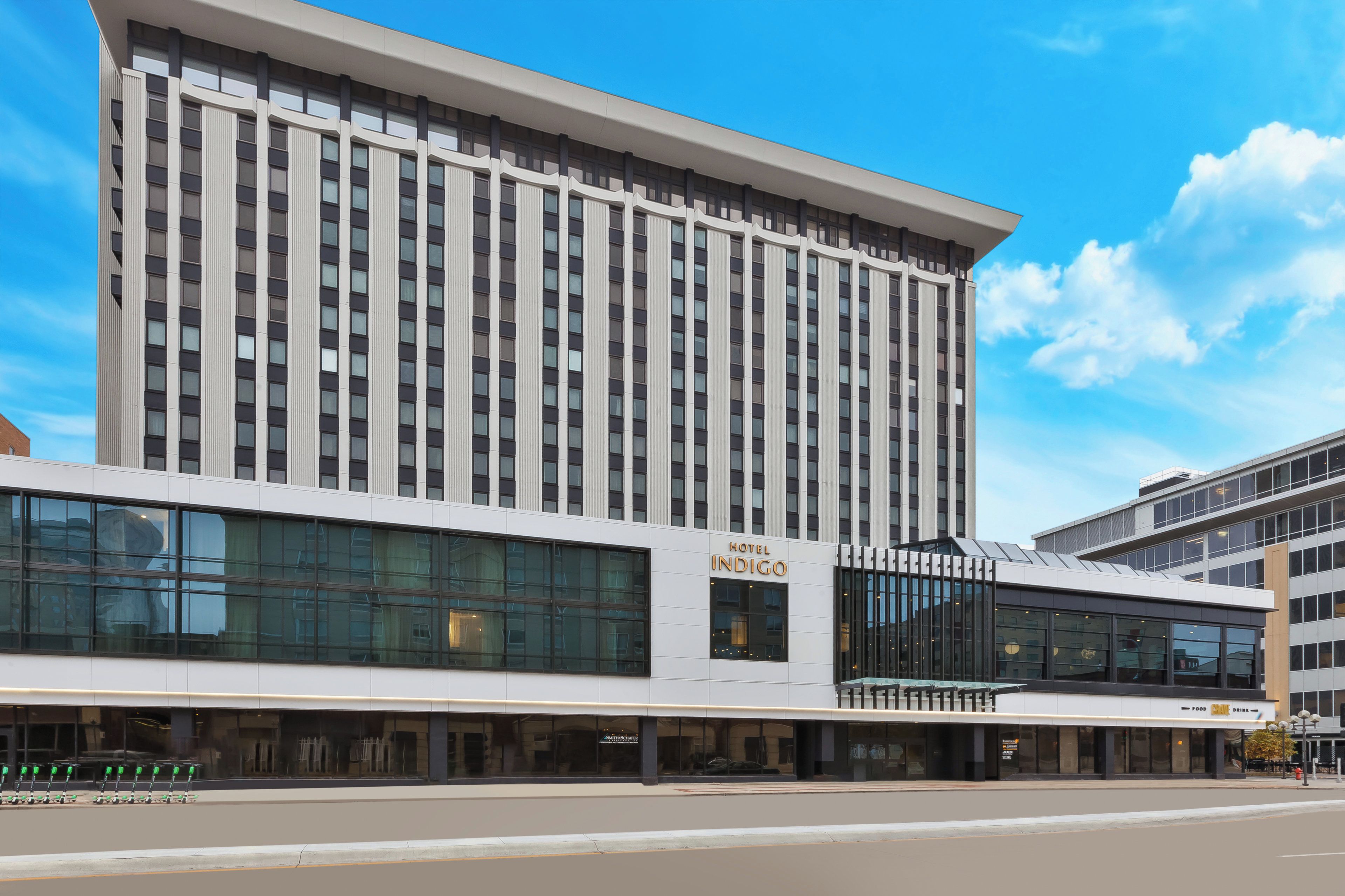 A modern hotel building with a prominent sign for 'Hotel Indigo.'