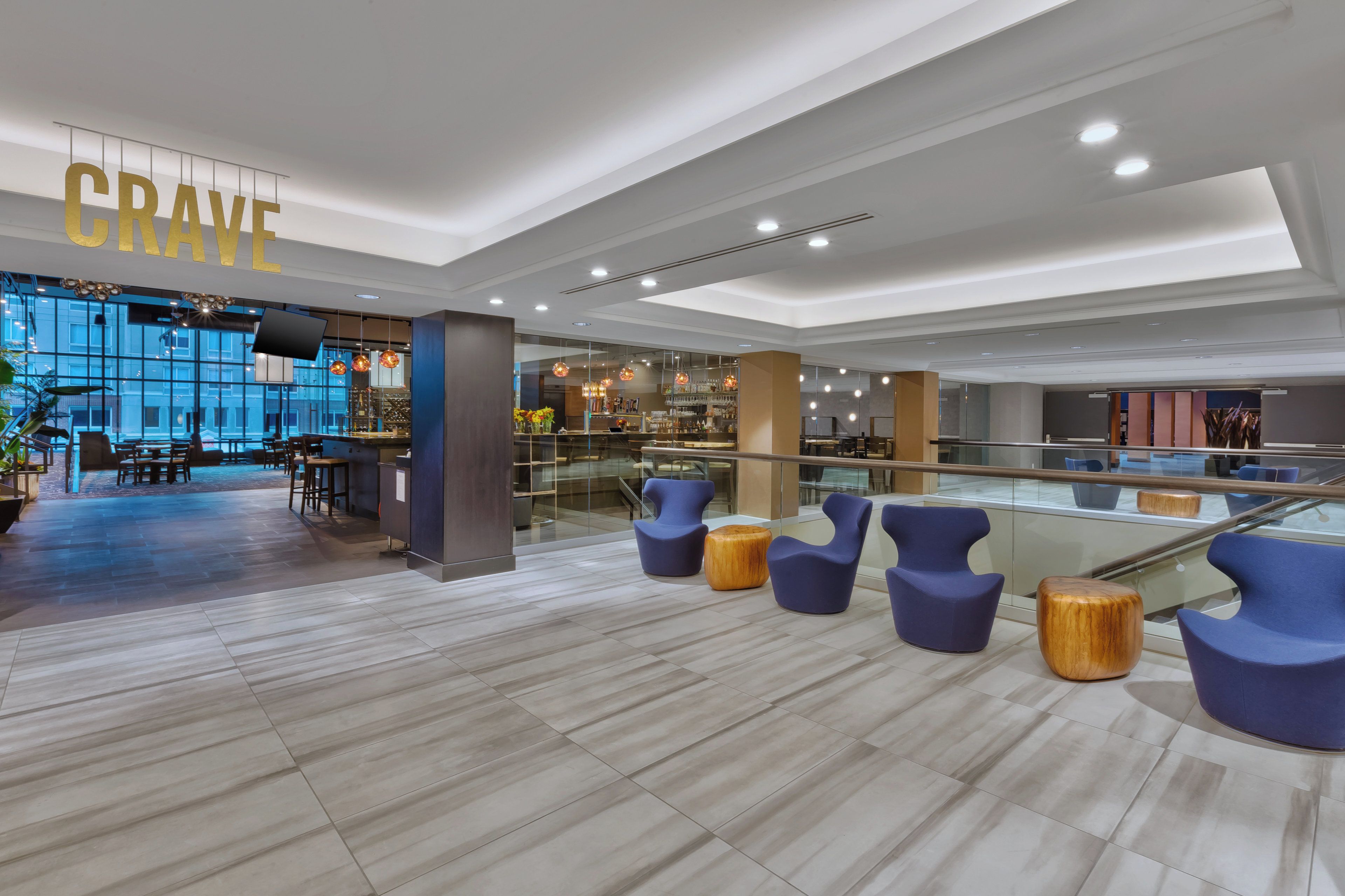 A modern interior with a bar area, seating, and a large window.