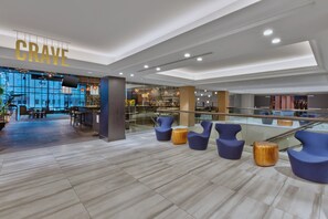 Un interior moderno con una zona de bar, asientos y un amplio ventanal.