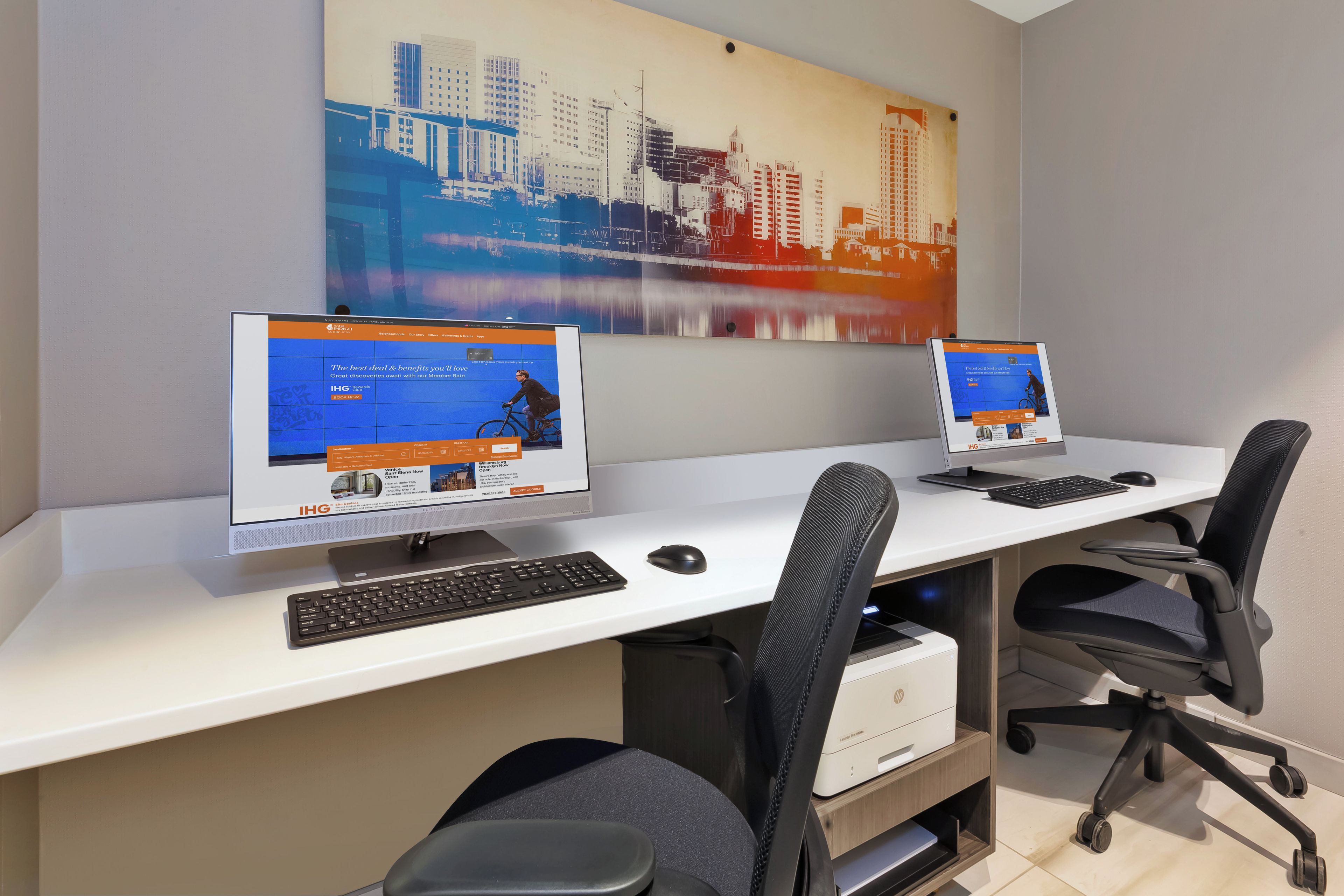 Un espace de travail équipé de deux ordinateurs de bureau, d’un clavier, d’une souris et de chaises de bureau.