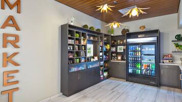 Een modern interieur met een houten plafond, een grote koelkast vol drankjes en planken met diverse producten.