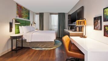 Een hotelkamer met een bed, bureau, stoel en een televisie.