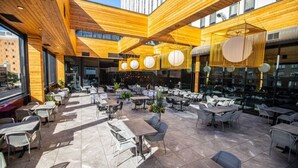 Een terras met houten balken, tafels en stoelen.