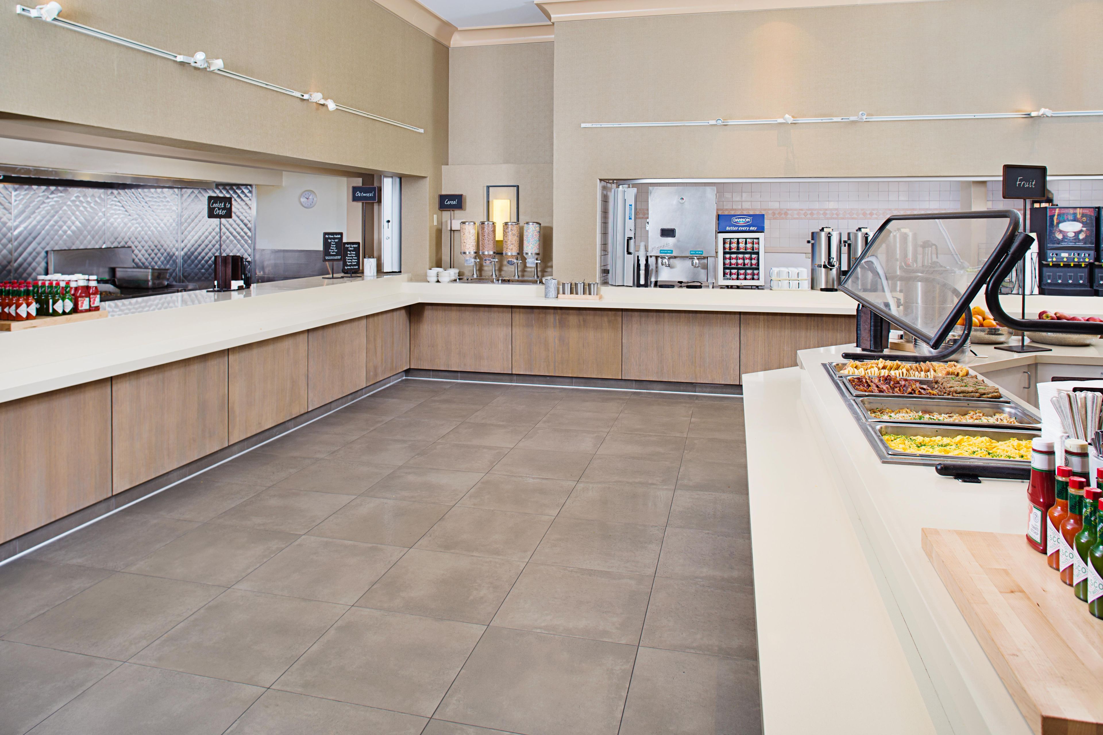 A buffet area with a variety of food stations, including a cereal station and a beverage dispenser.
