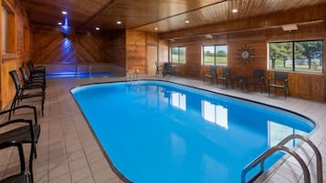 Una piscina con revestimiento de madera, suelo de baldosas y barandales de metal.
