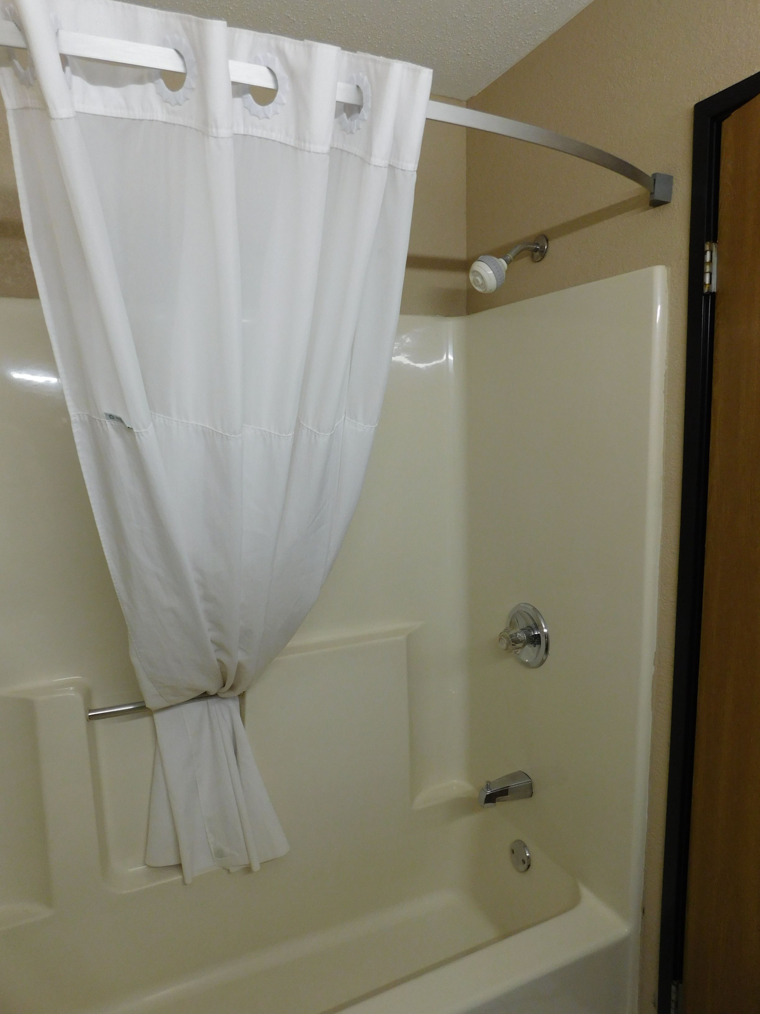 Un bagno con tenda da doccia, vasca e rubinetto.