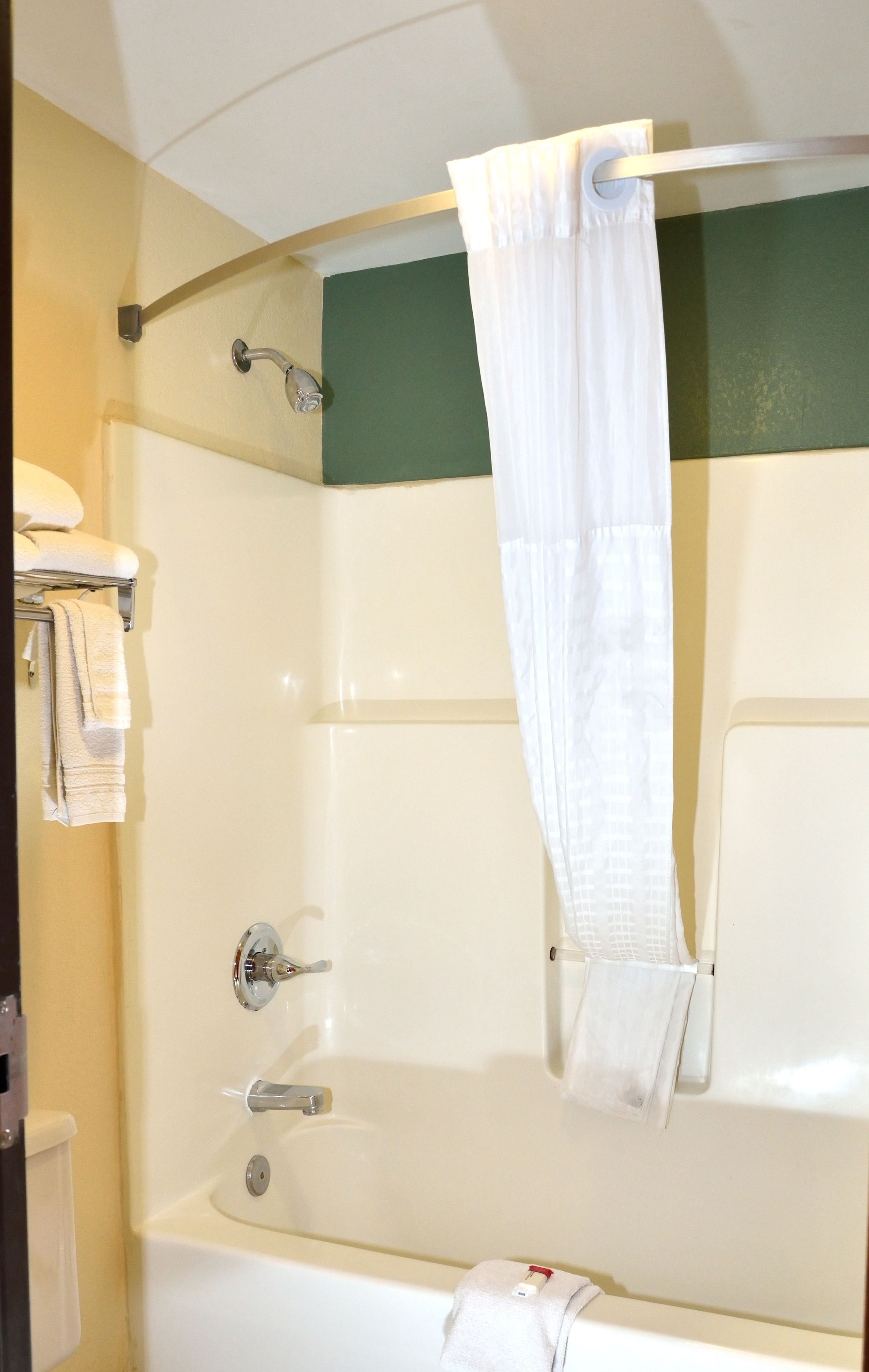 A bathroom with a bathtub, a shower, and a towel rack.