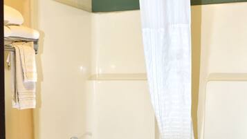 A bathroom with a bathtub, a shower, and a towel rack.