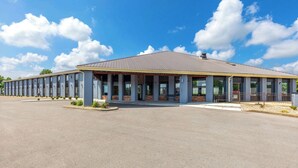 A modern building with a flat roof and large windows, surrounded by a paved area. - Days Inn by Wyndham Glasgow (Glasgow)