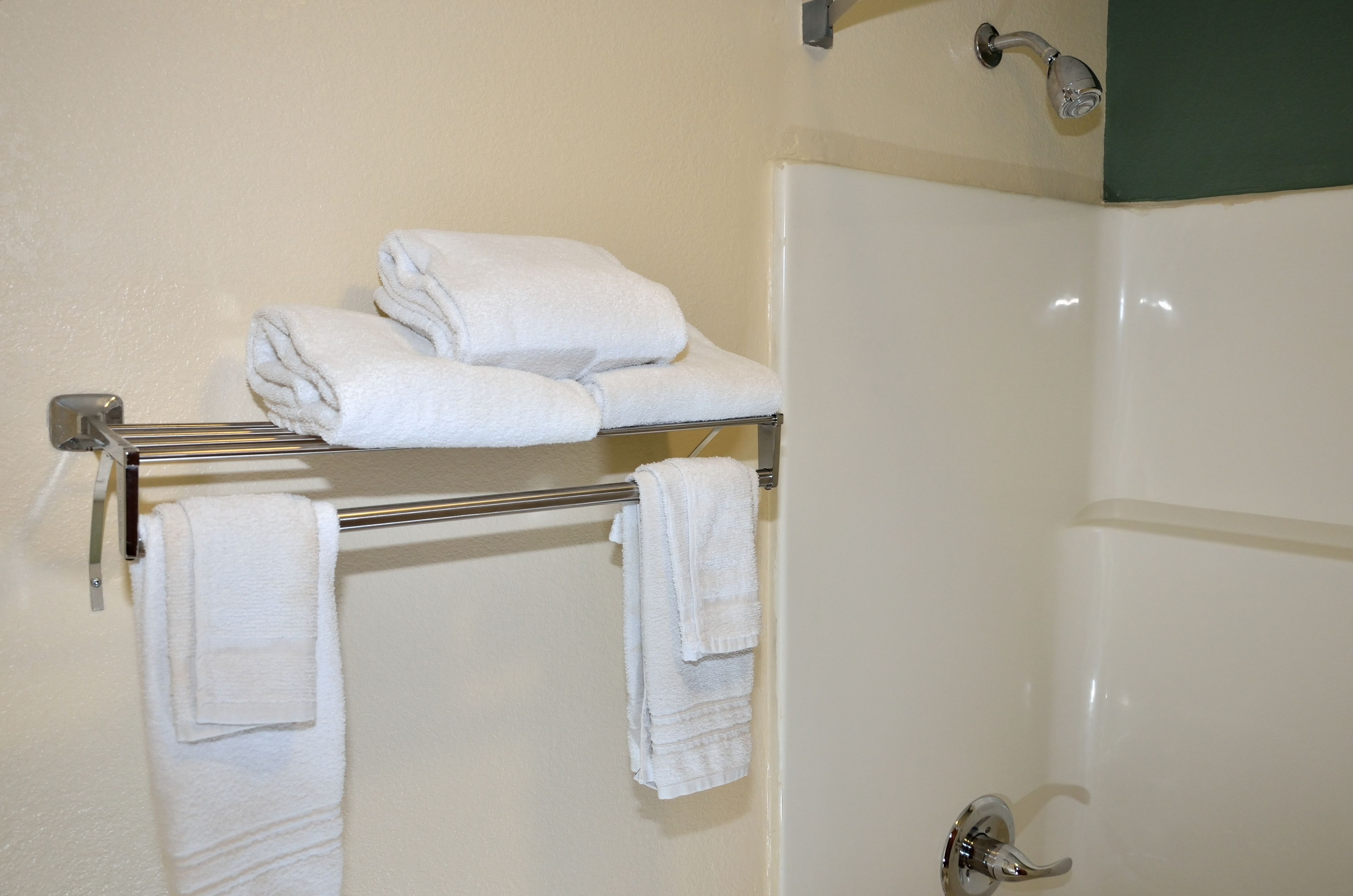 Casa de banho com um porta-toalhas com várias toalhas dobradas.