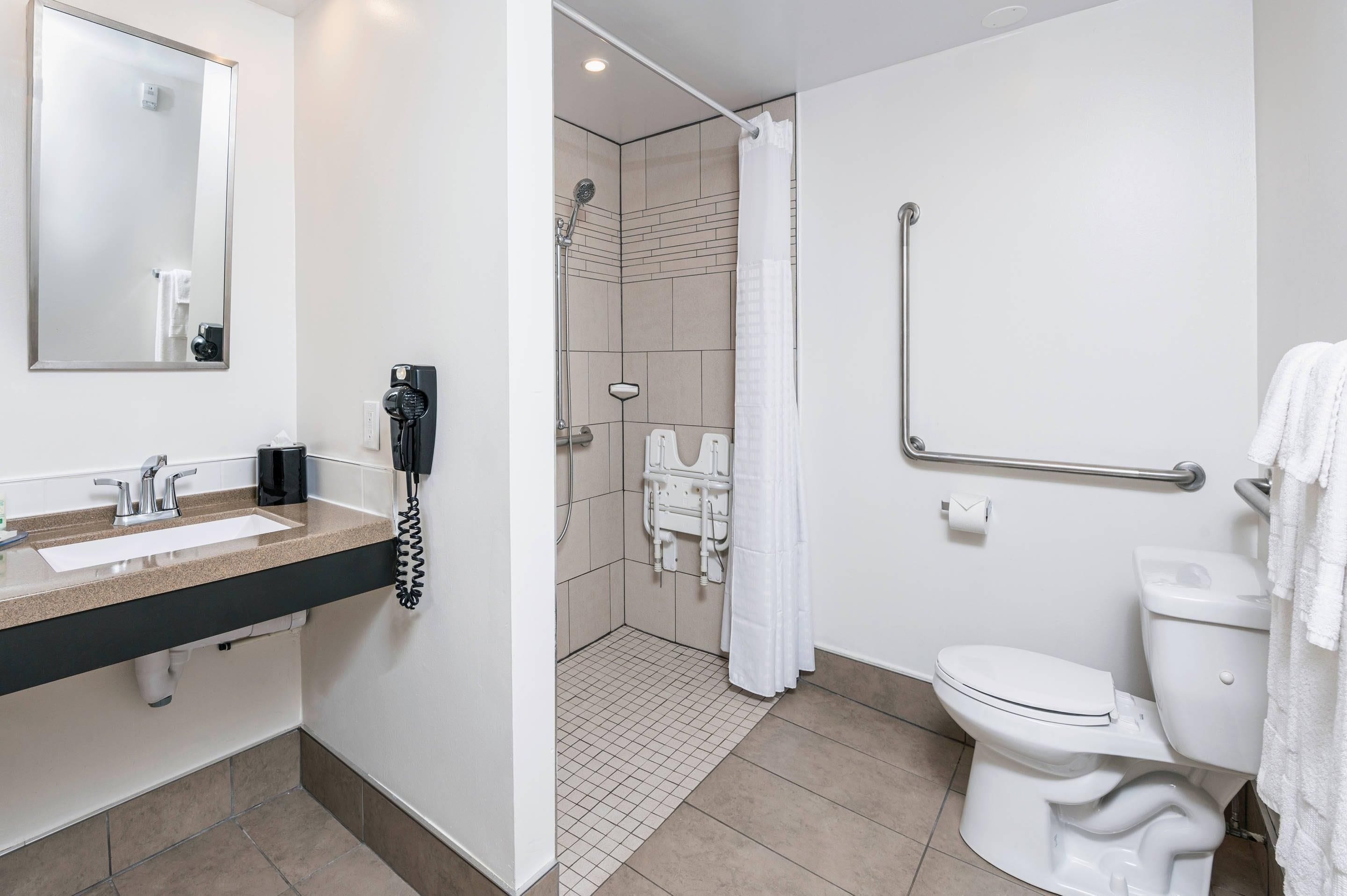 A modern bathroom with a shower, toilet, and sink.