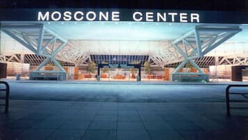 L’extérieur du centre Moscone présente une architecture moderne, avec une grande entrée ouverte et une enseigne bien visible.
