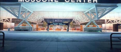 The exterior of the Moscone Center with a modern architectural design, featuring a large open entrance and a prominent sign.