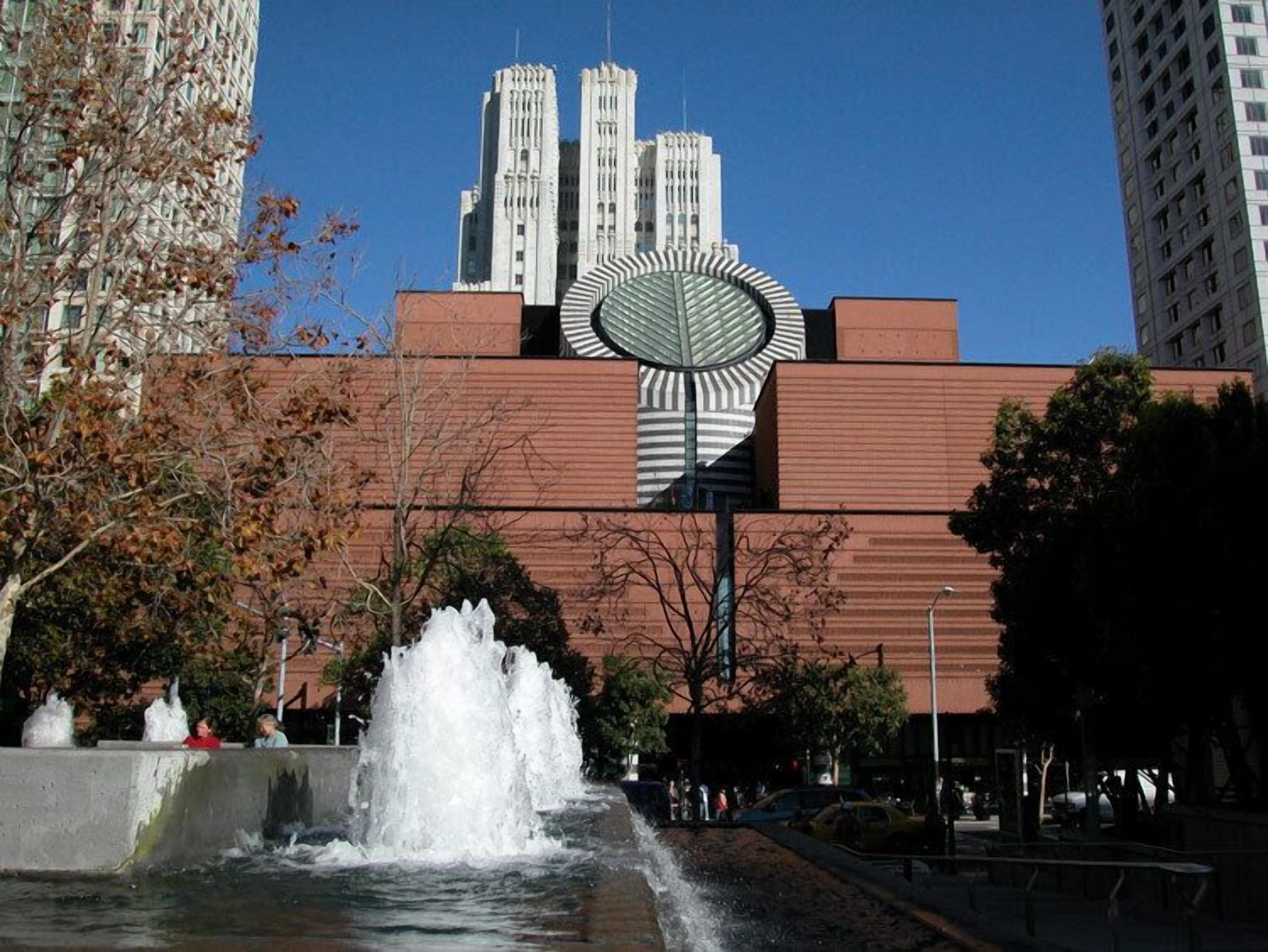 A building with a large, circular, striped structure in front.