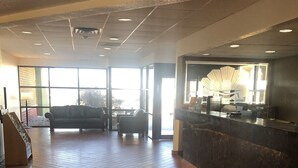 A spacious lobby with a reception desk, a sofa, and a staircase. - Motel 6 Lincoln, NE - Airport (Lincoln)
