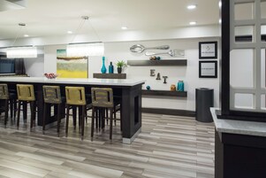 Una cocina moderna con barra, sillas de madera y una isla grande.