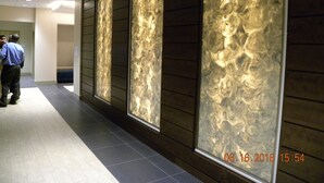 A hallway with large, illuminated wall panels and a tiled floor. - Holiday Inn Chicago North-Evanston by IHG (Evanston)