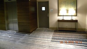 A hotel lobby with two elevators, a reception desk with a lamp, and a sign indicating 'Elevators'. - Holiday Inn Chicago North-Evanston by IHG (Evanston)