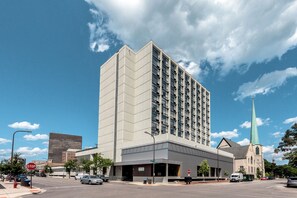 A multi-story building with a modern architectural design, featuring a prominent corner entrance and a large parking area. - Holiday Inn Chicago North-Evanston by IHG (Evanston)