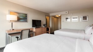 A hotel room with two beds, a desk with a chair, a television, a coffee maker, and framed artwork on the wall. - Holiday Inn Chicago North-Evanston by IHG (Evanston)
