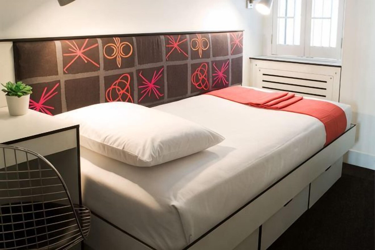 Une chambre à coucher moderne, avec un lit, un bureau et une chaise.