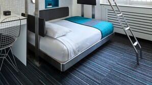 A bunk bed room with a ladder, a desk, and a chair.