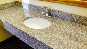 A bathroom sink with a granite countertop and a chrome faucet. - Motel 6 Macclenny, FL (MacClenny)