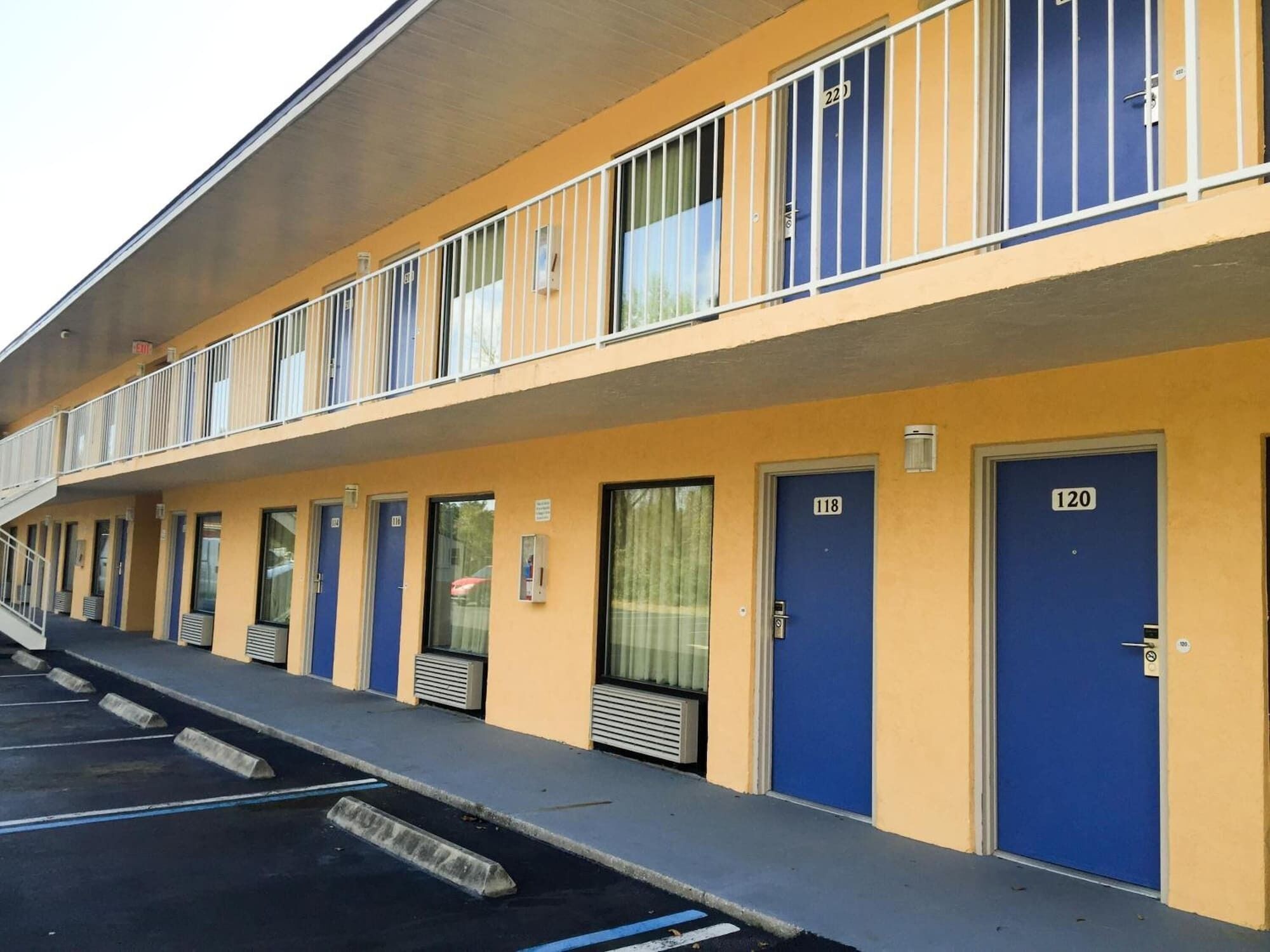Ein Motel mit mehreren Zimmern, jedes mit einer blauen Tür und einer Nummer.