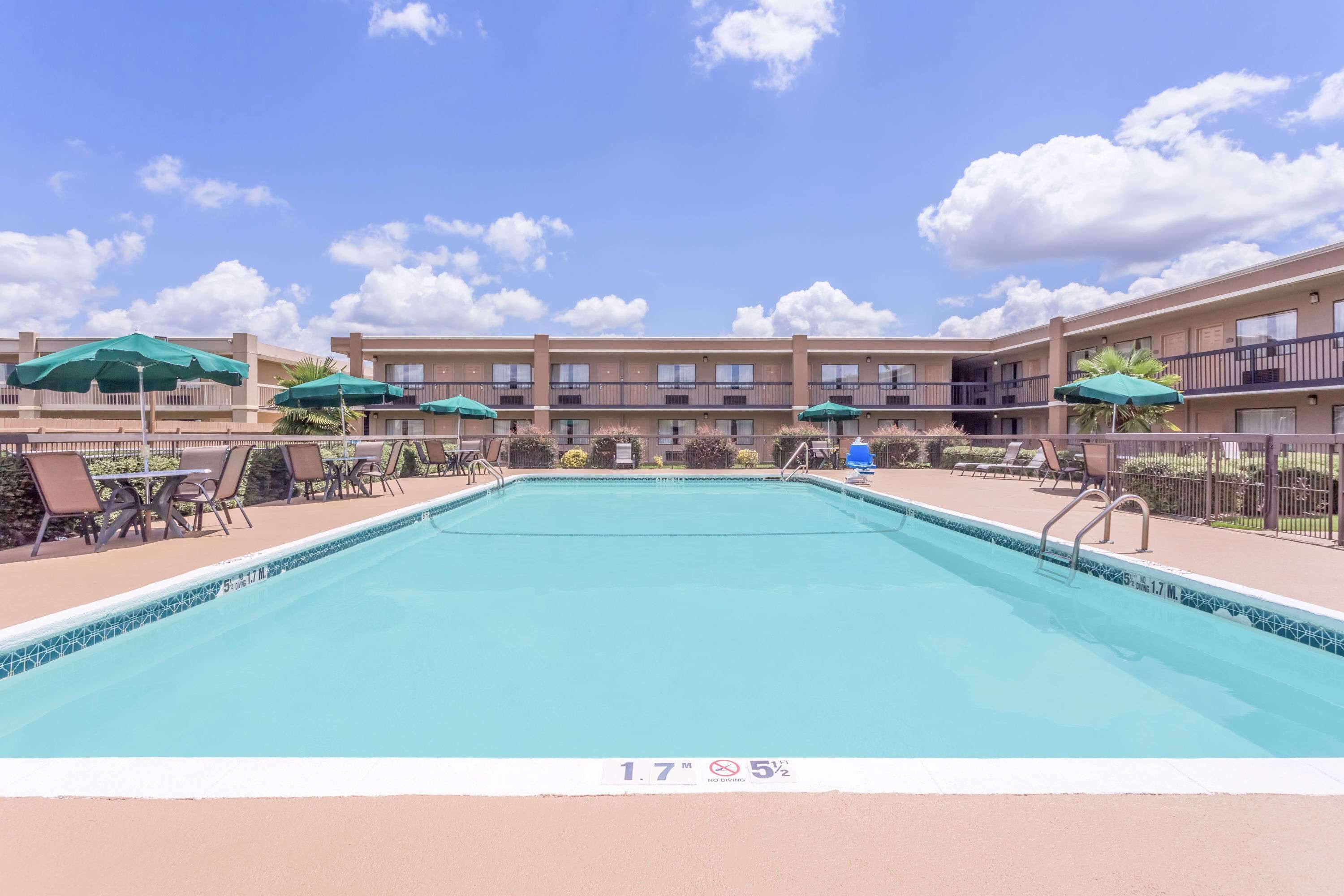 Een seizoensgebonden buitenzwembad en parasols bij het zwembad