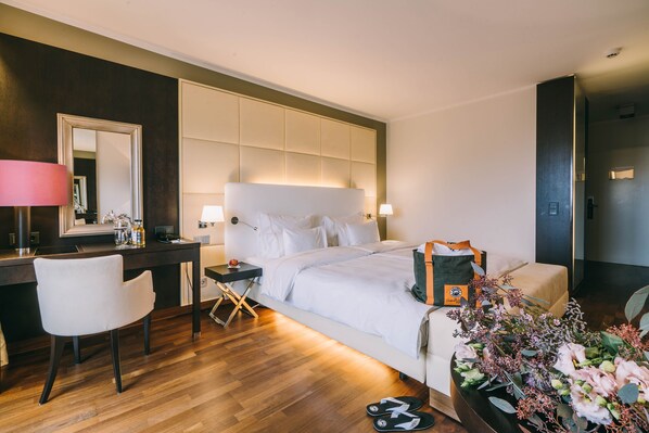 A hotel room with a large bed, bedside tables, a desk, a chair, and a mirror. - Hotel Reiters Supreme (Bad Tatzmannsdorf)