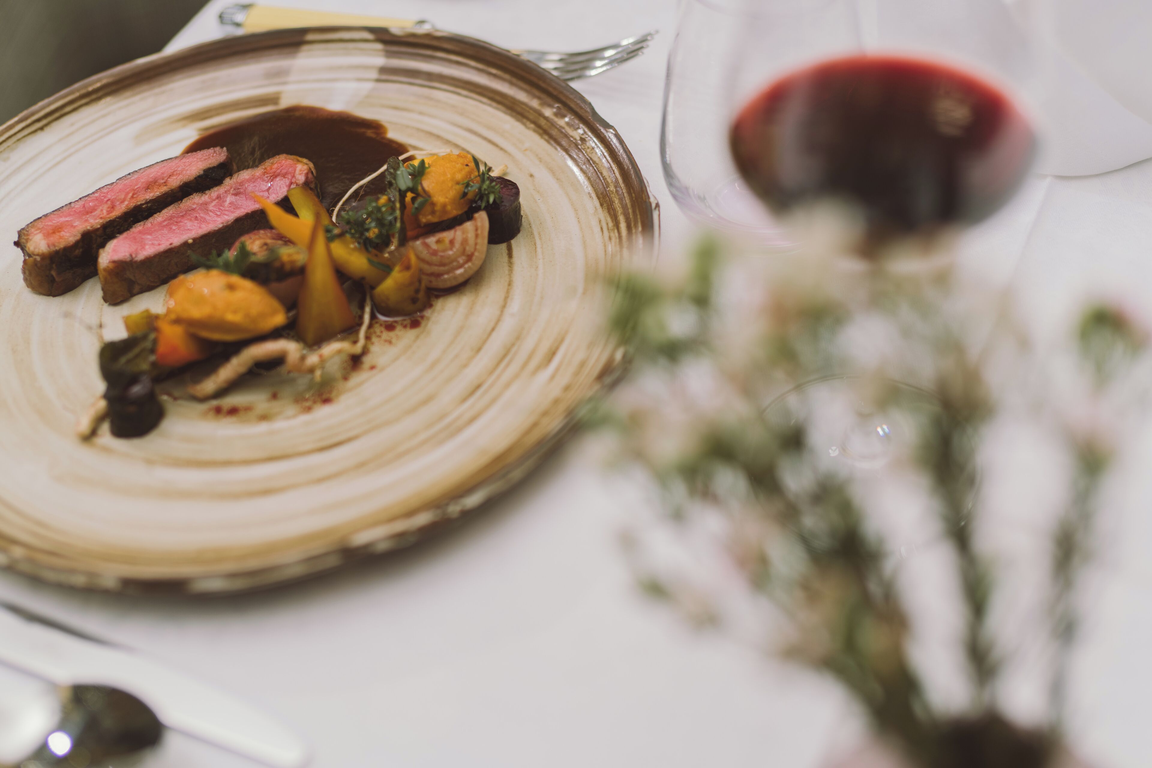 Ein Teller Essen mit einem Glas Rotwein.