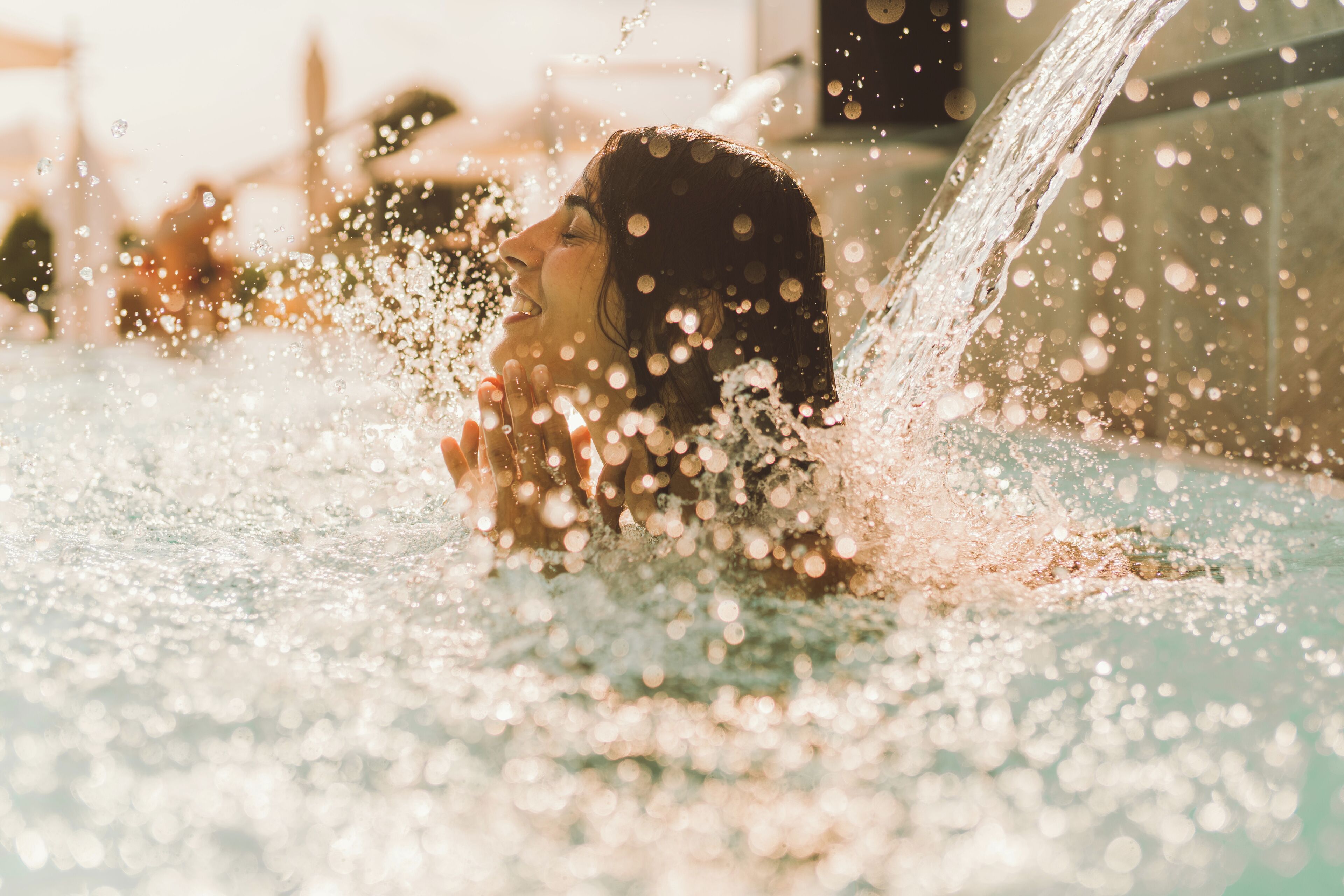 A person in a pool with water splashing around them.