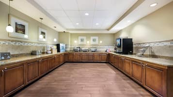 A spacious kitchen with wooden cabinets, granite countertops, and a tiled backsplash.