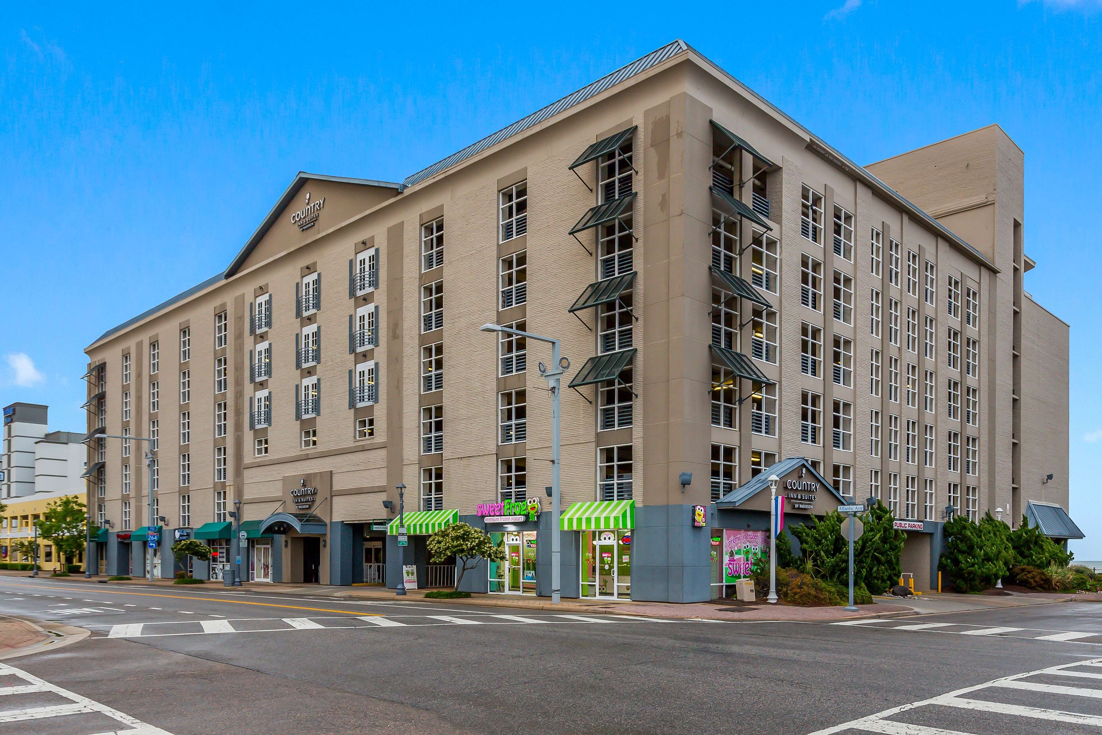 A large hotel building with multiple floors, a flat roof, and a prominent entrance with a green awning.