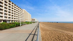 A beachfront hotel with a long, straight promenade leading to the beach.