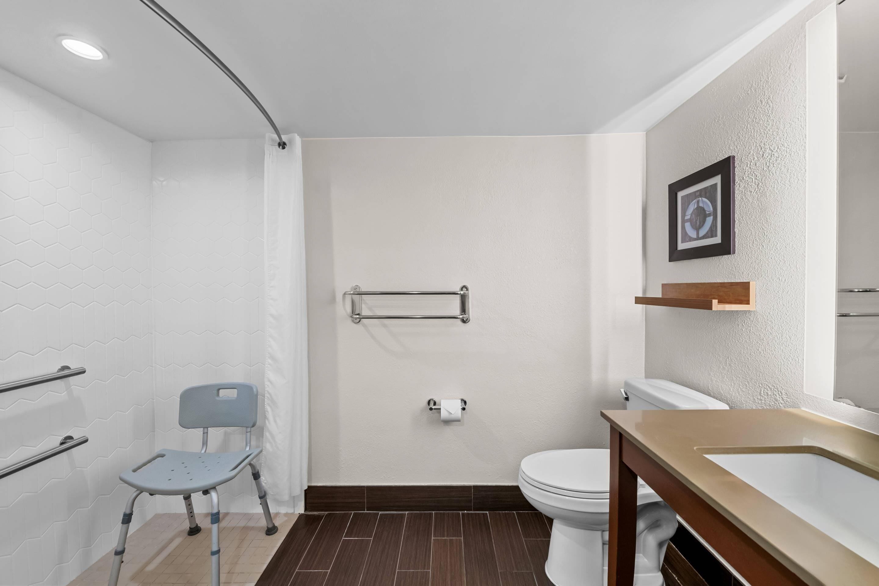 A modern bathroom with a shower, toilet, and sink.