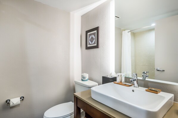 A bathroom with a white sink, a mirror, and a toilet. - Country Inn & Suites by Radisson, Virginia Beach (Oceanfront) (Virginia Beach)