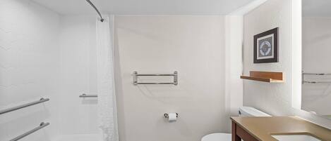 A modern bathroom with a shower, toilet, and sink.