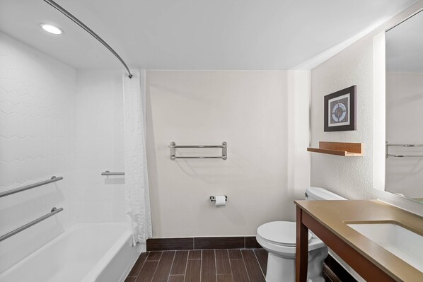 A modern bathroom with a shower, toilet, and sink.
