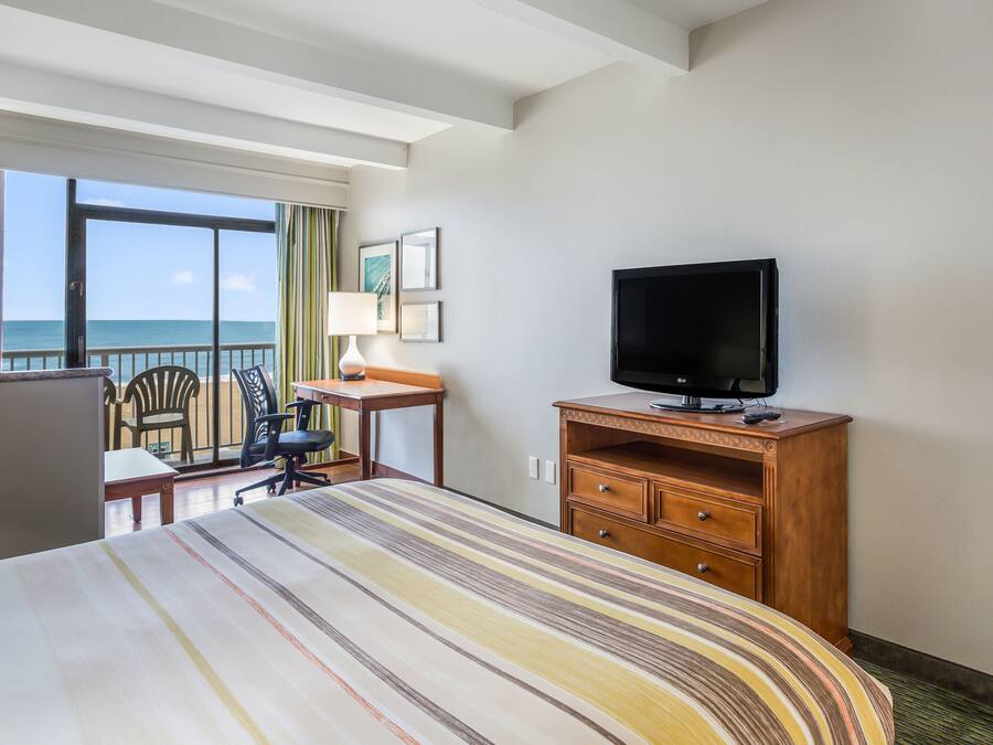 Habitació d'hotel amb llit, escriptori, televisió i vistes a l'oceà.