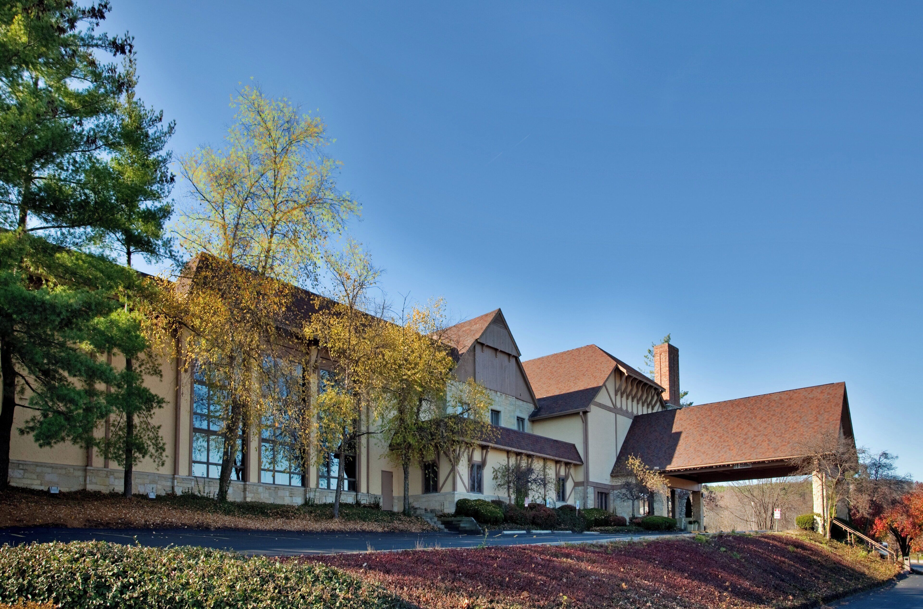 A large, two-story building with a prominent gabled roof and multiple windows.