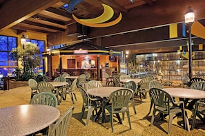 Un restaurant avec une terrasse, un bar et une enseigne Budweiser.