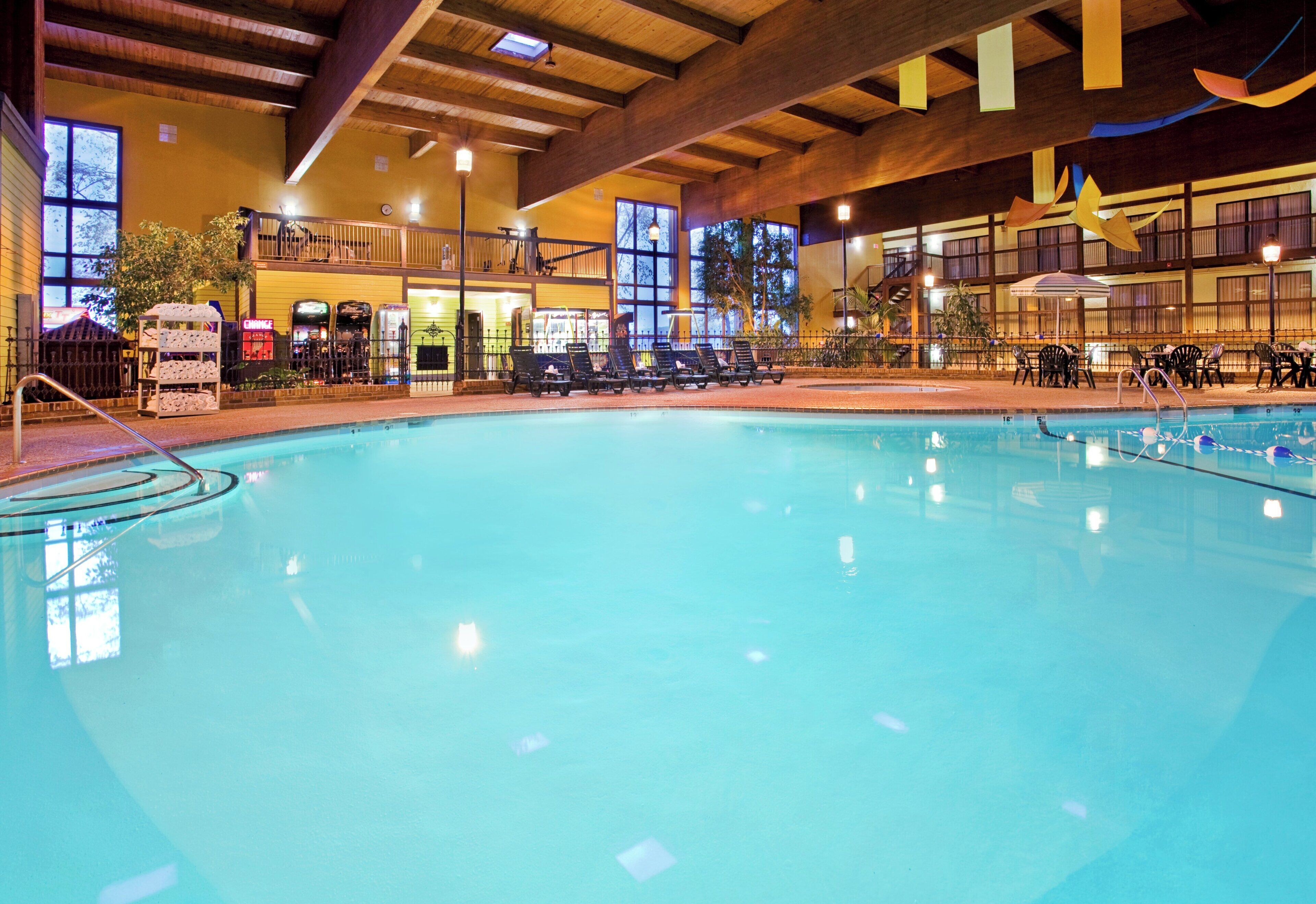 Une piscine intérieure avec des chaises longues et une terrasse ensoleillée.