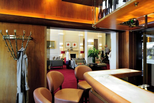 A hotel lobby with a reception desk, seating area, and a fireplace.