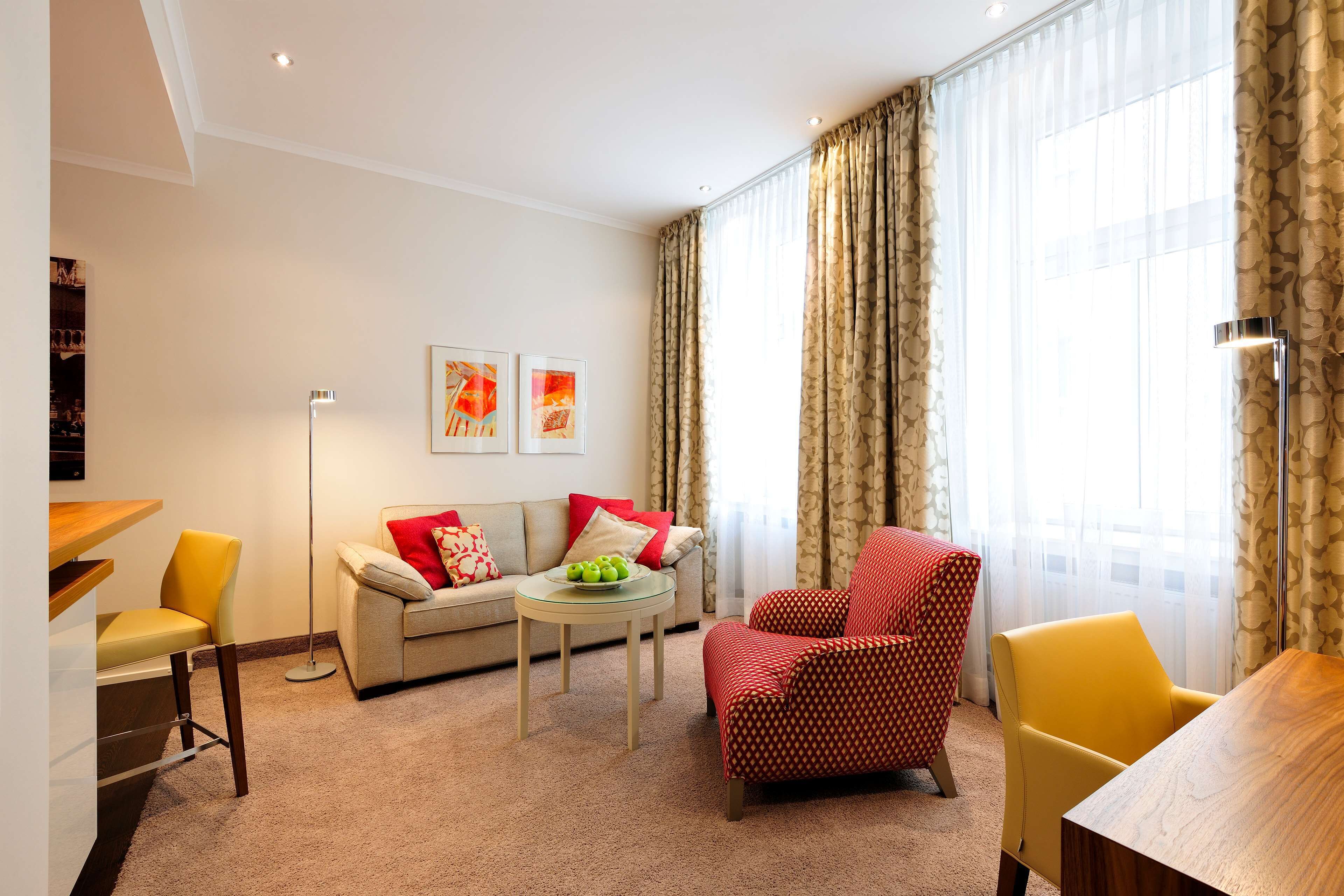 Un salon comprenant un canapé, des fauteuils, une table basse et une table à manger.