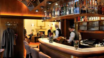 Eine Bar mit Theke, Sitzgelegenheiten und einer Auswahl an Flaschen und Gläsern.