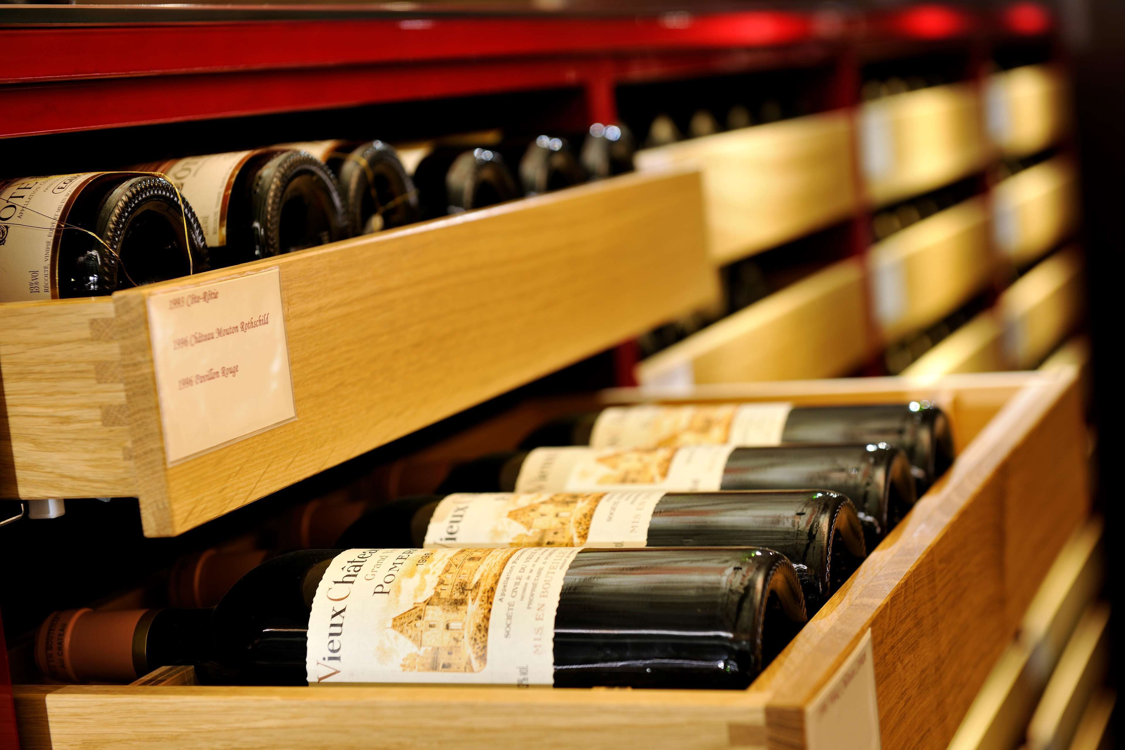 A wooden wine rack with bottles labeled 'Vieux Chateau.'