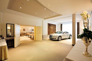 A spacious hotel lobby with a white car, a dining area, and a large mirror. - Kastens Hotel Luisenhof (Hannover)